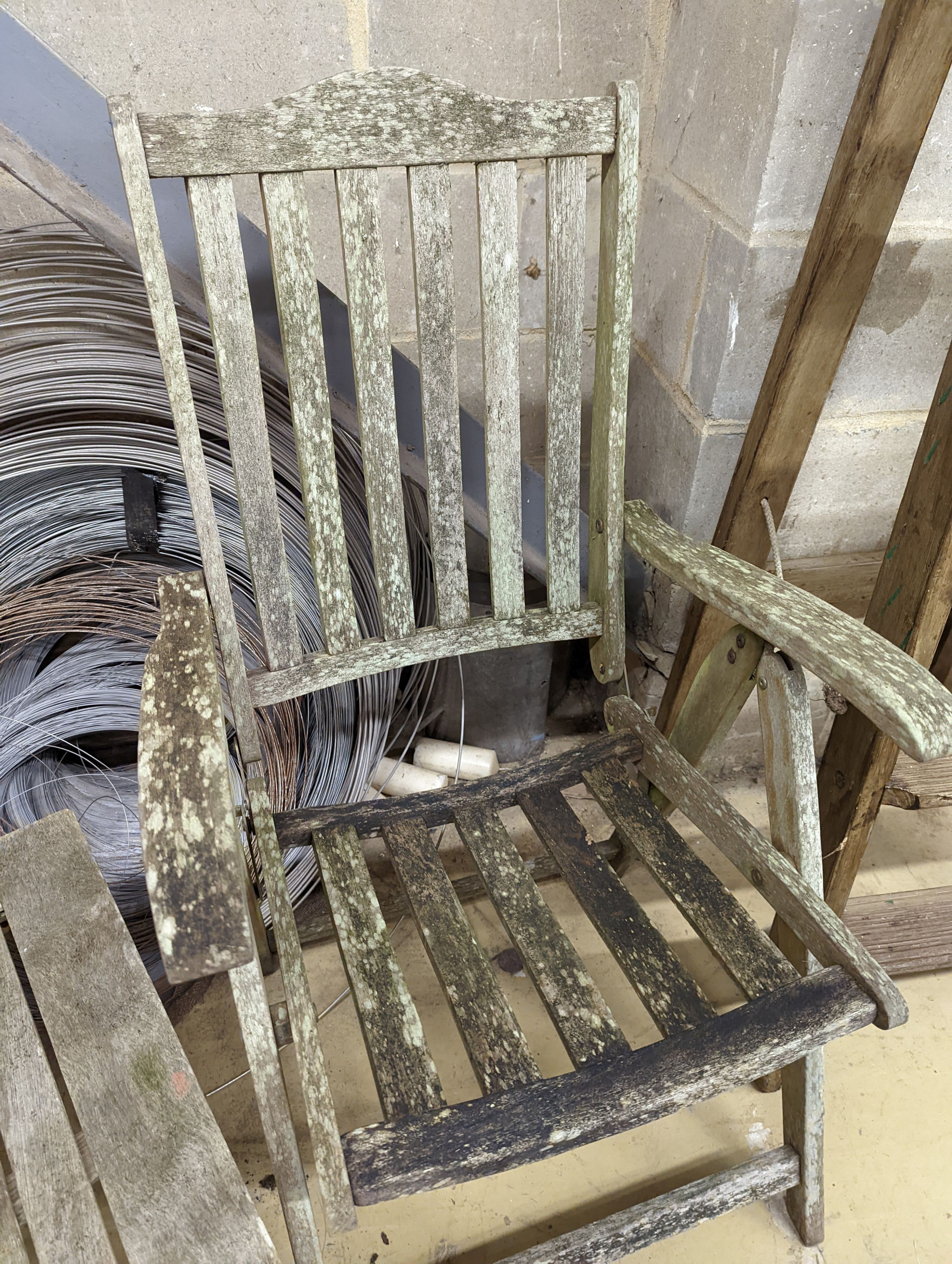 Two weathered teak folding garden armchairs and a low table